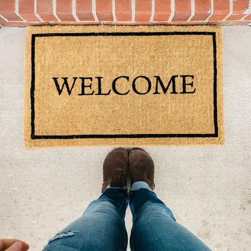 A welcome mat with a person standing in front of it