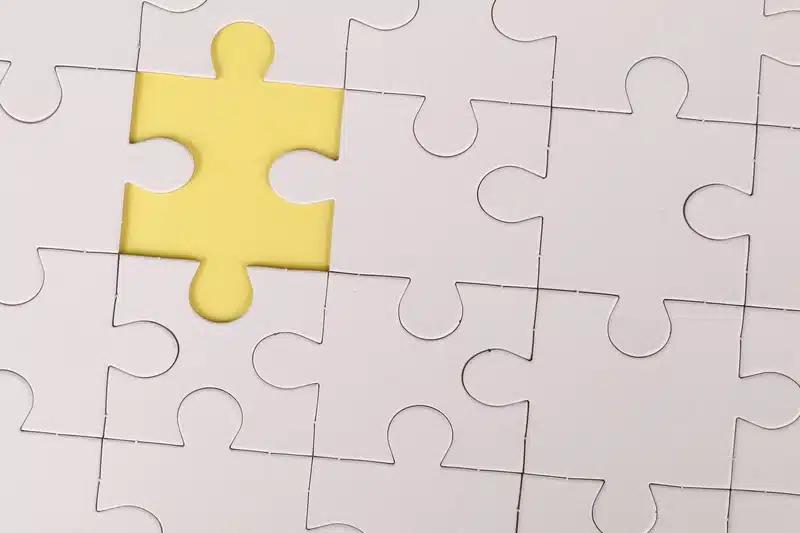 grey puzzle assembled with one yellow piece