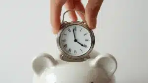 Clock being placed inside a piggy bank