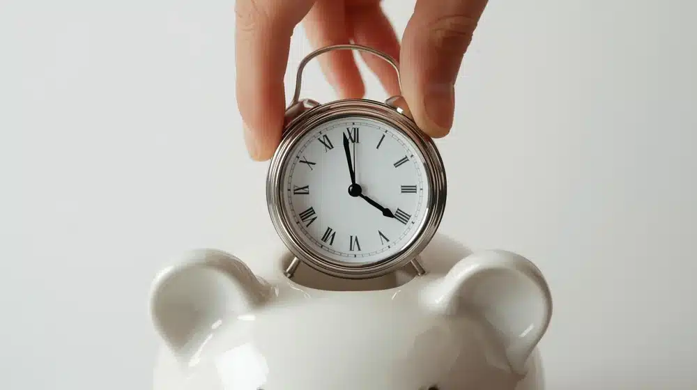 Clock being placed inside a piggy bank